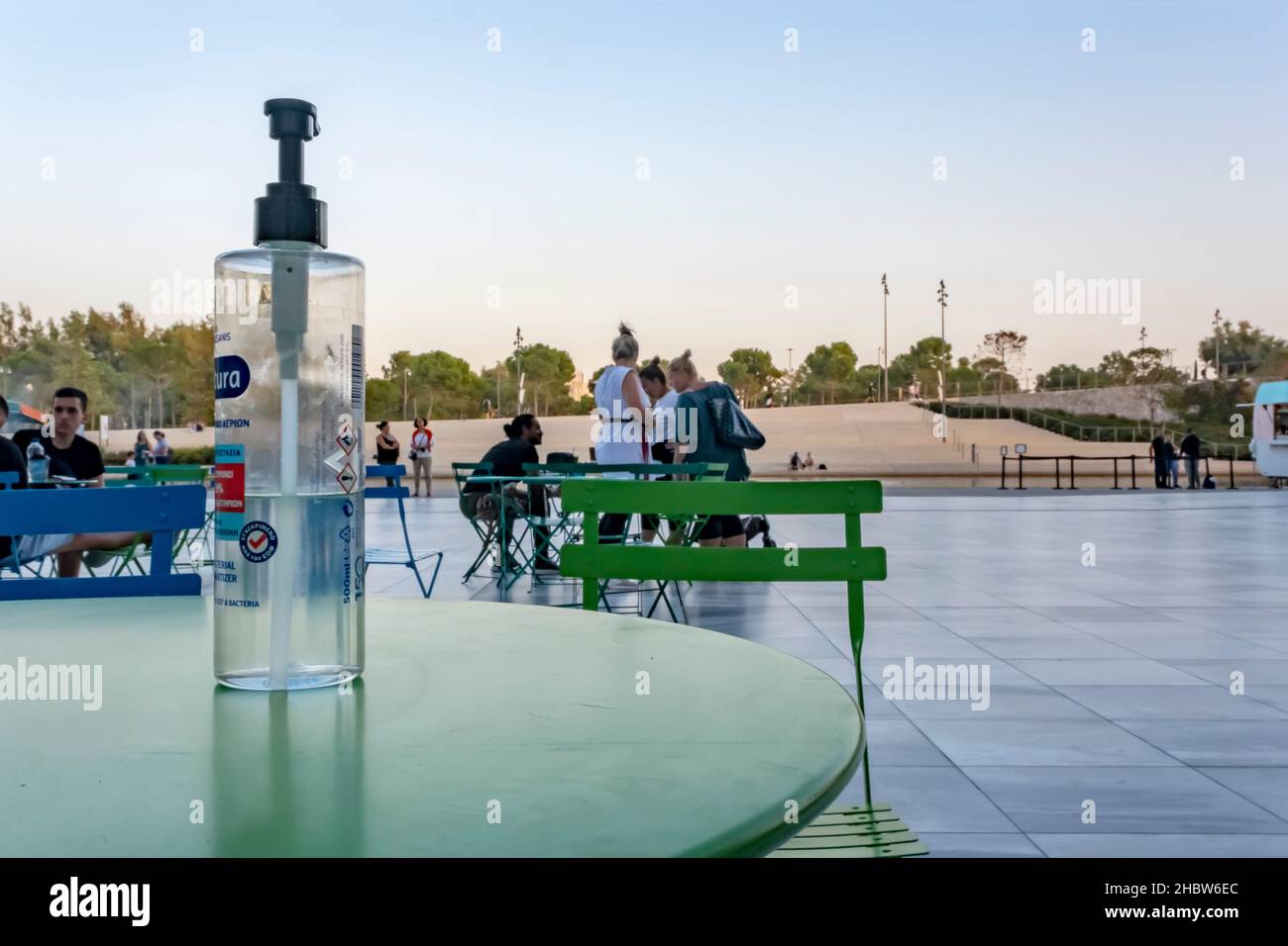 Athènes, Grèce - 27 septembre 2021 : grande bouteille d'assainisseur pour les mains avec pompe sur la table.Le café de rue à l'époque du coronavirus a rouvert ses portes en été. Banque D'Images
