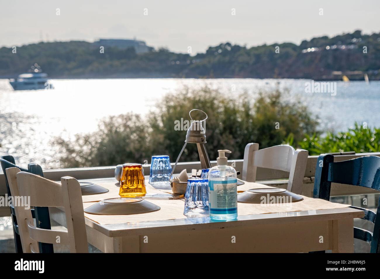 Athènes, Grèce - 29 septembre 2021 : table préparée avec de la vaisselle et une bouteille d'assainisseur pour les mains.Restaurant avec vue incroyable attendant les clients. Banque D'Images