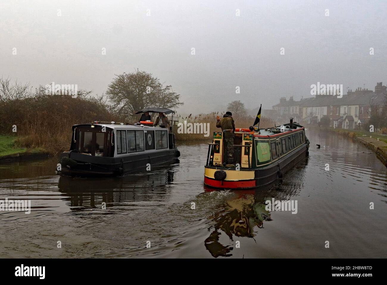 Les bateaux-canaux passent dans la brume.Un bateau à rames sur la route de Halsall est passé par le bateau de voyage local sur le canal de Leeds et Liverpool près de Burscough. Banque D'Images