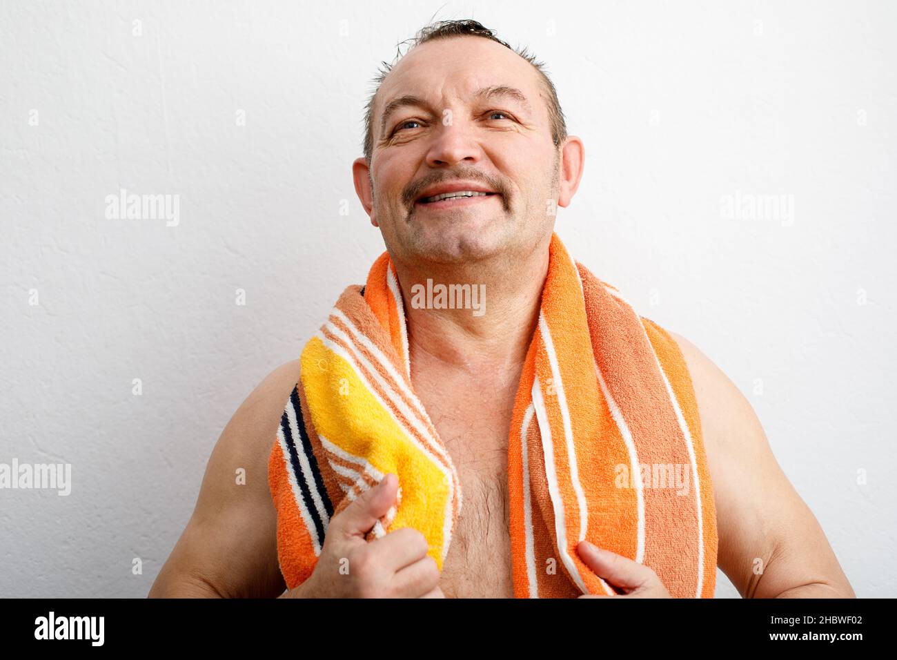 Un portrait d'un homme âgé très content.Je suis sorti de la douche avec une serviette autour de son cou Banque D'Images