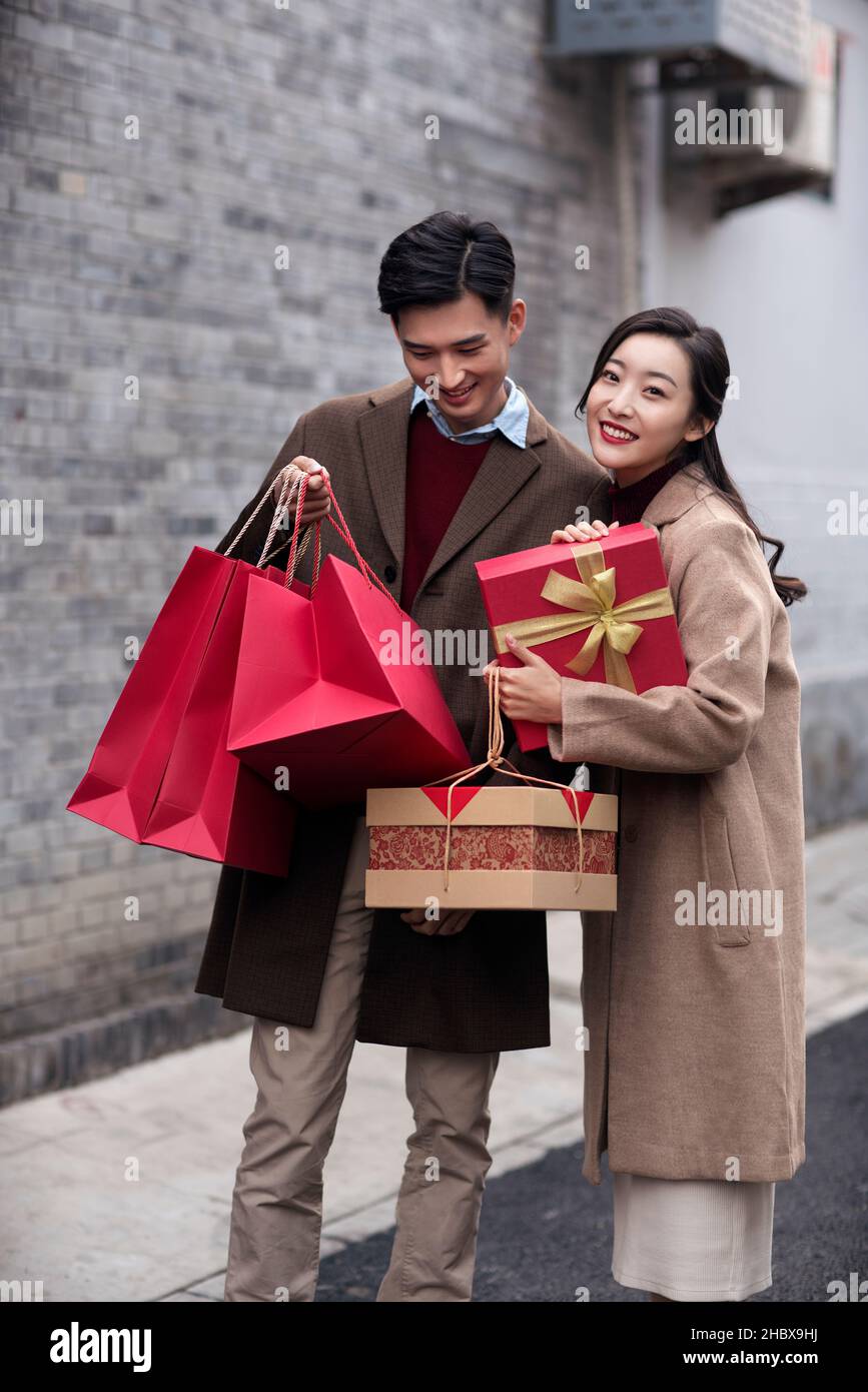 Jeunes amoureux heureux portant des cadeaux Banque D'Images