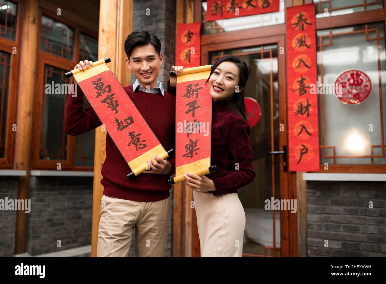 Un jeune couple heureux tenant des couplets pour célébrer la nouvelle année Banque D'Images