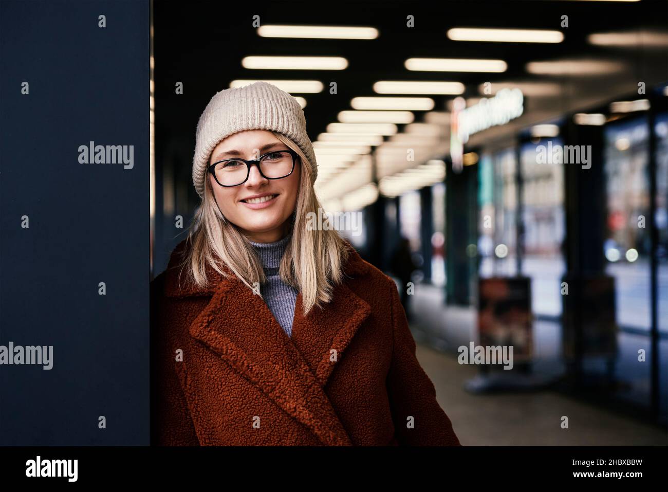 Portrait d'une belle femme souriante dans des lunettes.Femme portant un manteau en ville.Marche dans la rue Banque D'Images
