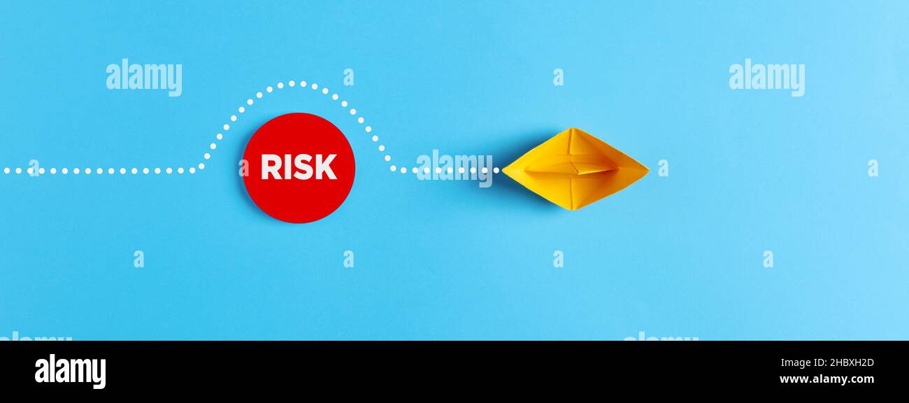 Le bateau à voile en papier vient autour de l'obstacle du risque.L'évitement des risques dans le concept d'entreprise. Banque D'Images