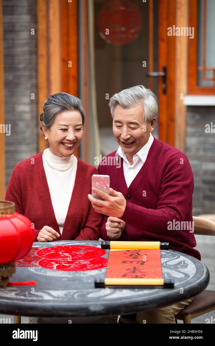 Couple âgé utilisant un smartphone pour les appels vidéo dans la nouvelle année Banque D'Images