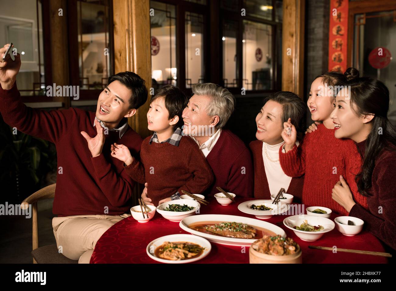 Des familles heureuses qui prennent des selfies avec leur téléphone mobile pendant le dîner de la Saint-Sylvestre Banque D'Images