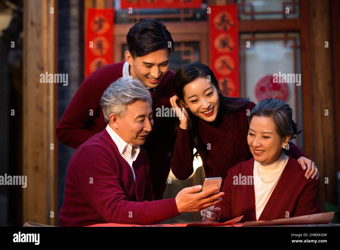 Une famille heureuse utilisant son smartphone pour les appels vidéo au cours de la nouvelle année Banque D'Images