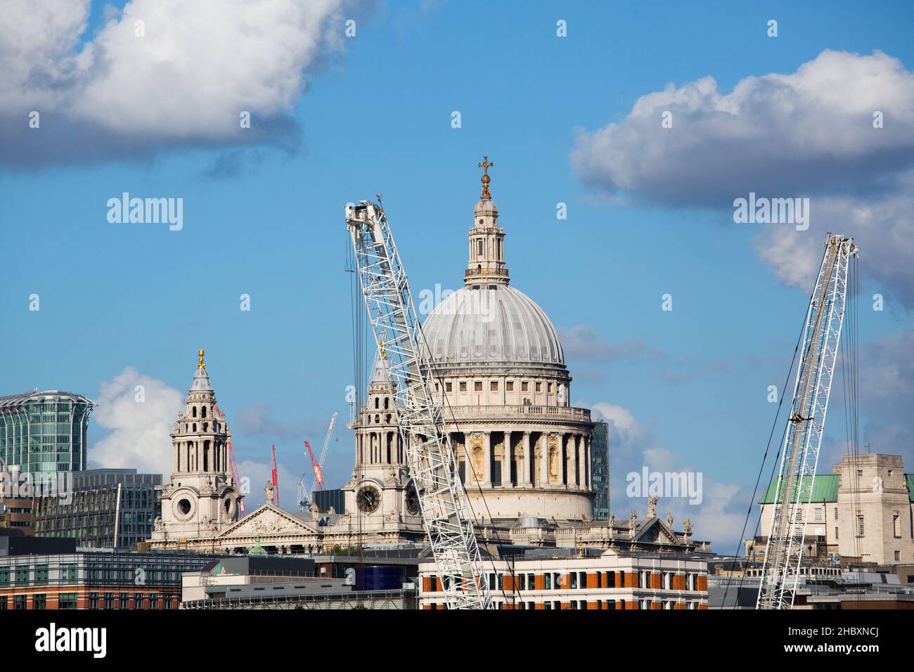 Vue sur la cathédrale de St.Pauls depuis le pont avec ciel bleu et grands nuages et grues de construction Banque D'Images