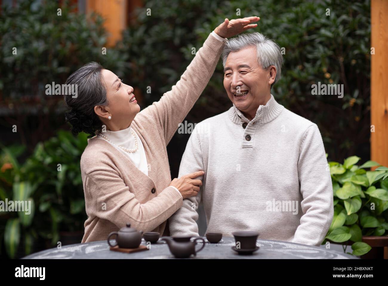 Un vieux couple qui boit du thé et bavarde dans la cour Banque D'Images