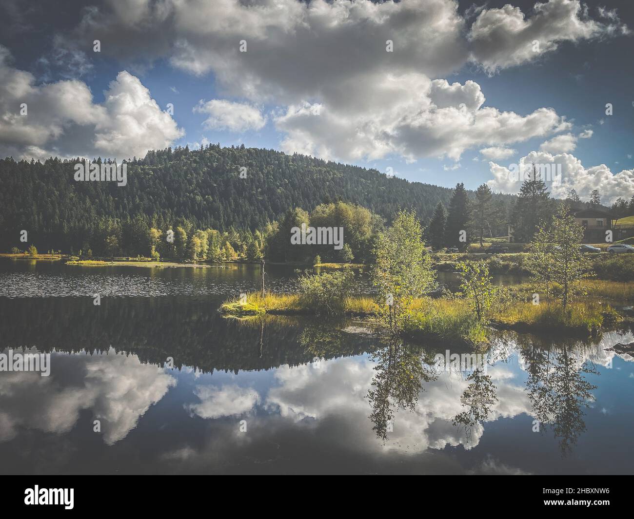 De beaux nuages se reflètent dans l'eau du lac de Lispach dans la Bresse, Vosges Banque D'Images