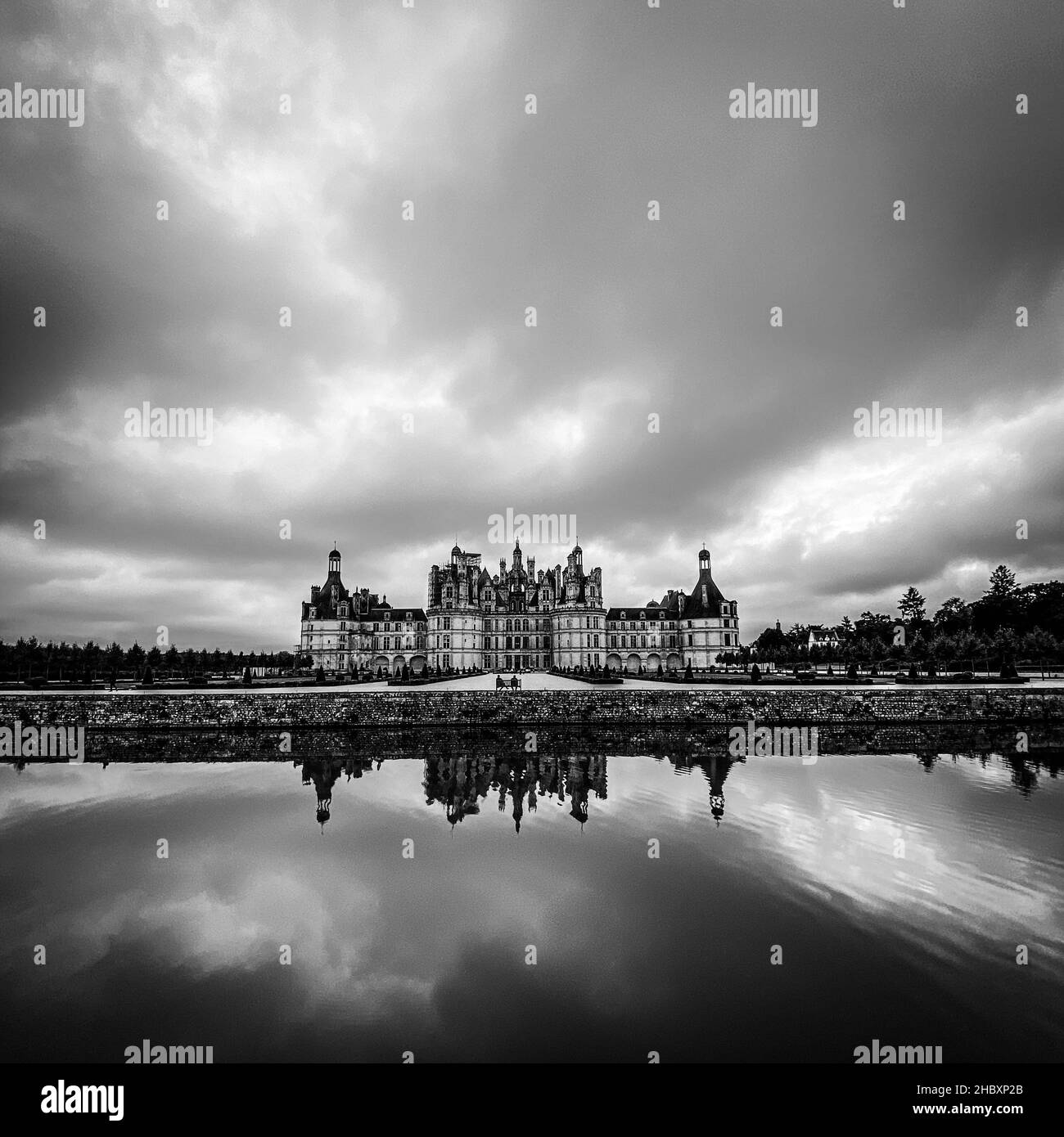 Vue panoramique du château de Chambord dans la vallée de la Loire, avec ses jardins, jour nuageux, reflet de l'eau, France Banque D'Images