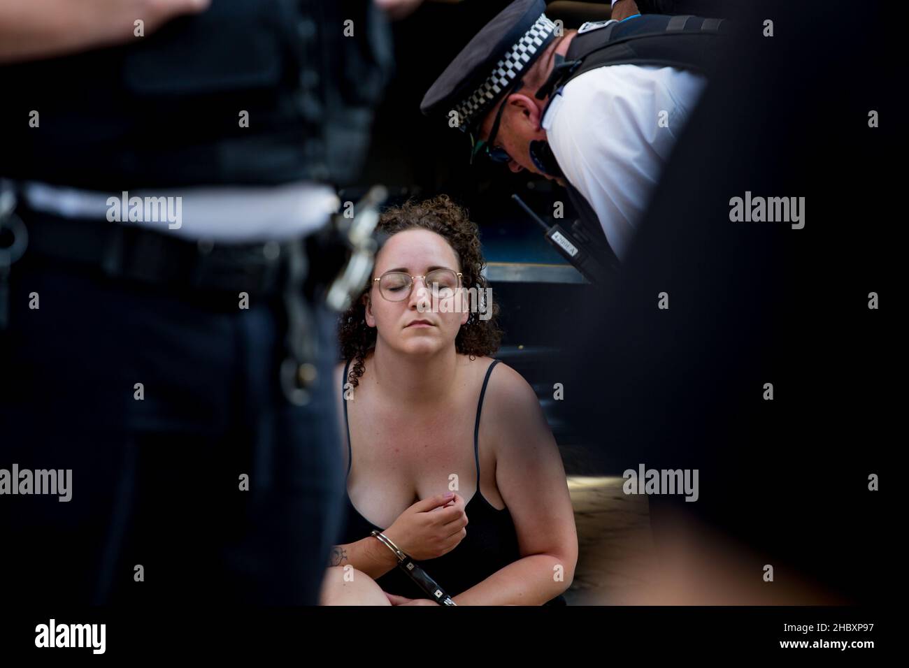 Une militante rebelle animale arrêtée à Londres avec les yeux fermés et la police penchée sur son Londres 2020 Banque D'Images