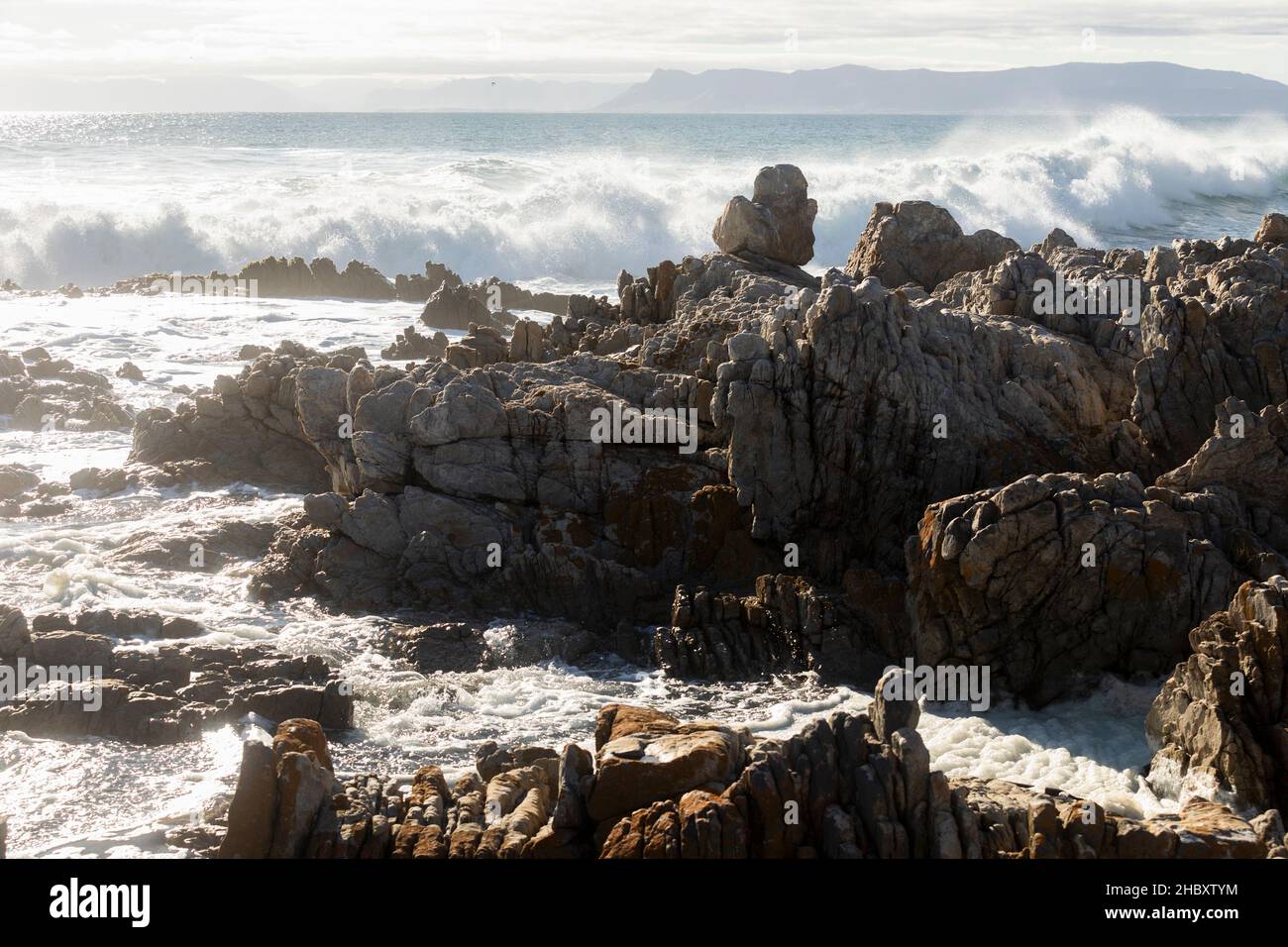 Rochers déchiquetés sur le rivage à de Kelders, de grandes vagues se déroulant et se brisant sur les rochers Banque D'Images