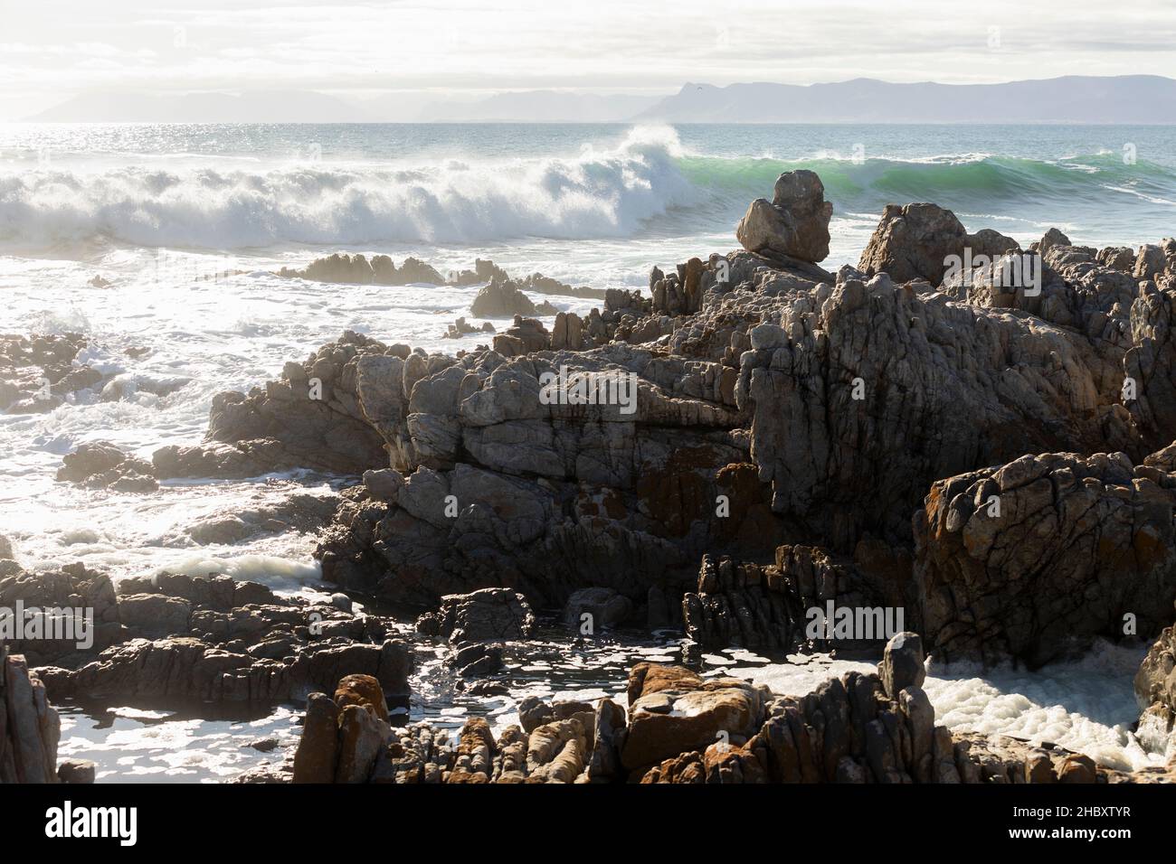 Rochers déchiquetés sur le rivage à de Kelders, de grandes vagues se déroulant et se brisant sur les rochers Banque D'Images