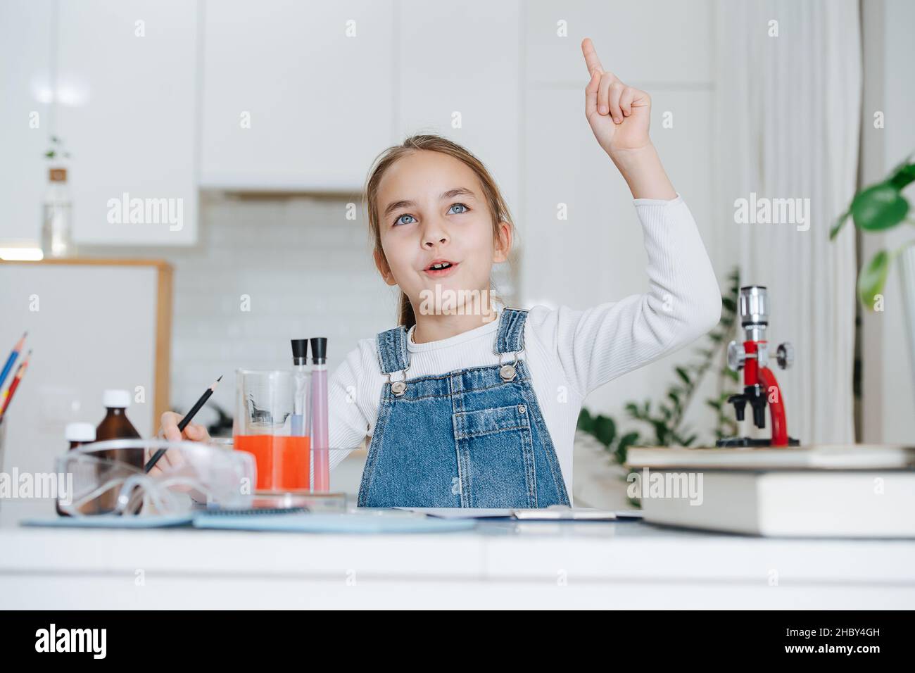 Une petite fille enthousiaste qui fait un projet de science à la maison, ayant un moment eureka Banque D'Images