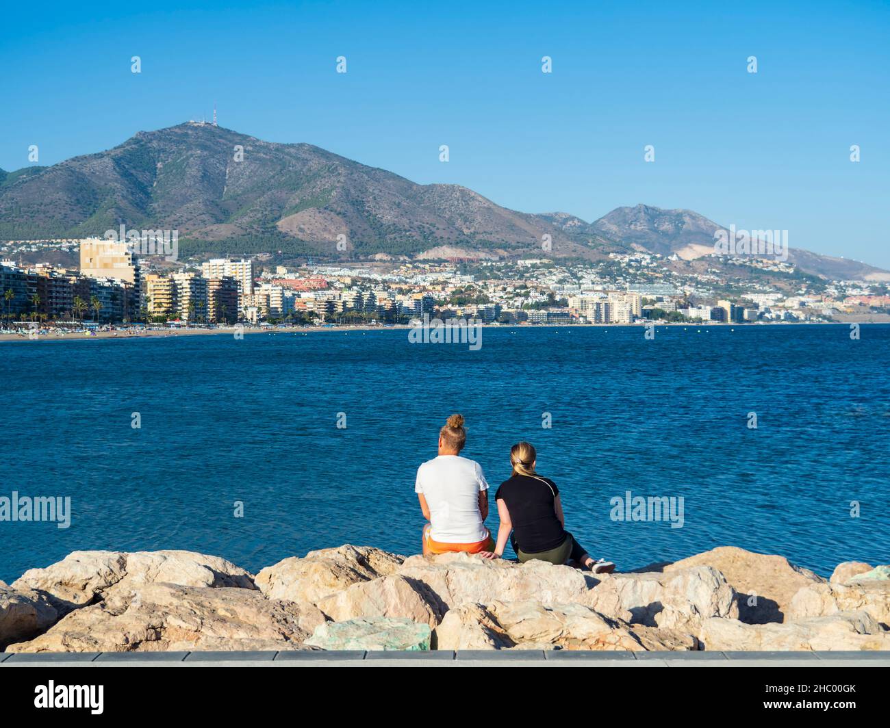Un couple regardant la mer depuis un quai dans le port de Fuengirola. Banque D'Images