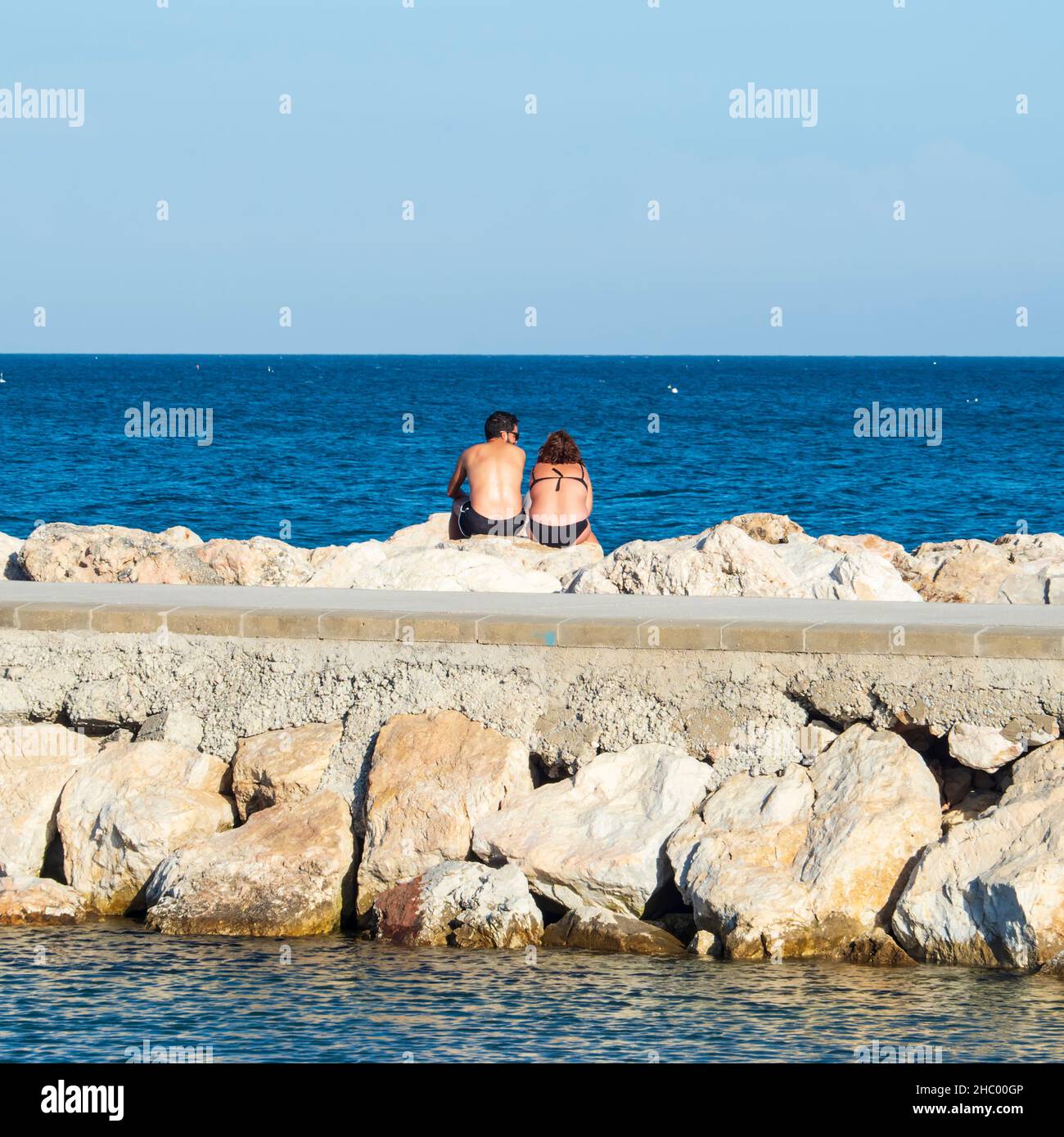 Un couple regardant la mer depuis un quai dans le port de Fuengirola. Banque D'Images