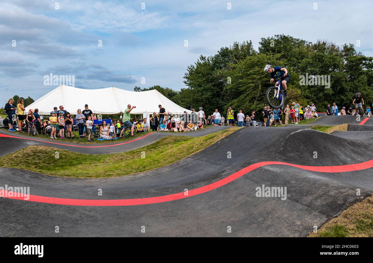 Garçon à vélo faisant une roue sur la piste de pompe Ormiston BMX, East Lothian, Écosse, Royaume-Uni Banque D'Images