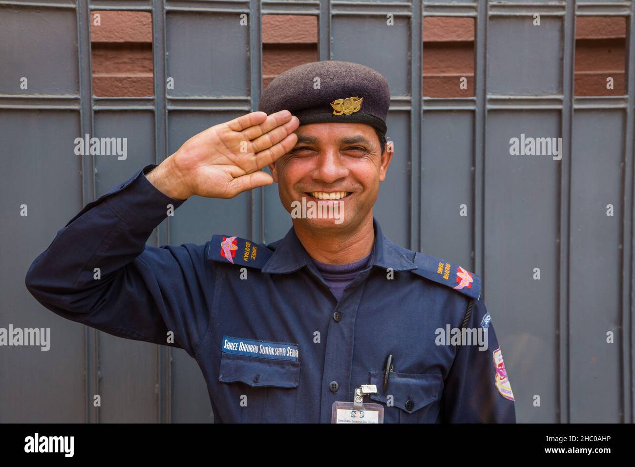 Un garde de sécurité privée en uniforme salue avec le sourire une entreprise à Katmandou, au Népal. Banque D'Images