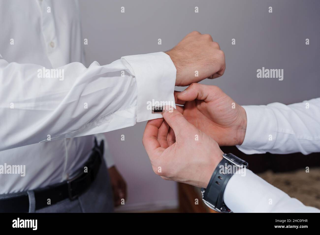 Homme attachant un lien de manchette sur la chemise.Le marié fixe les boutons de manchette sur la chemise Banque D'Images