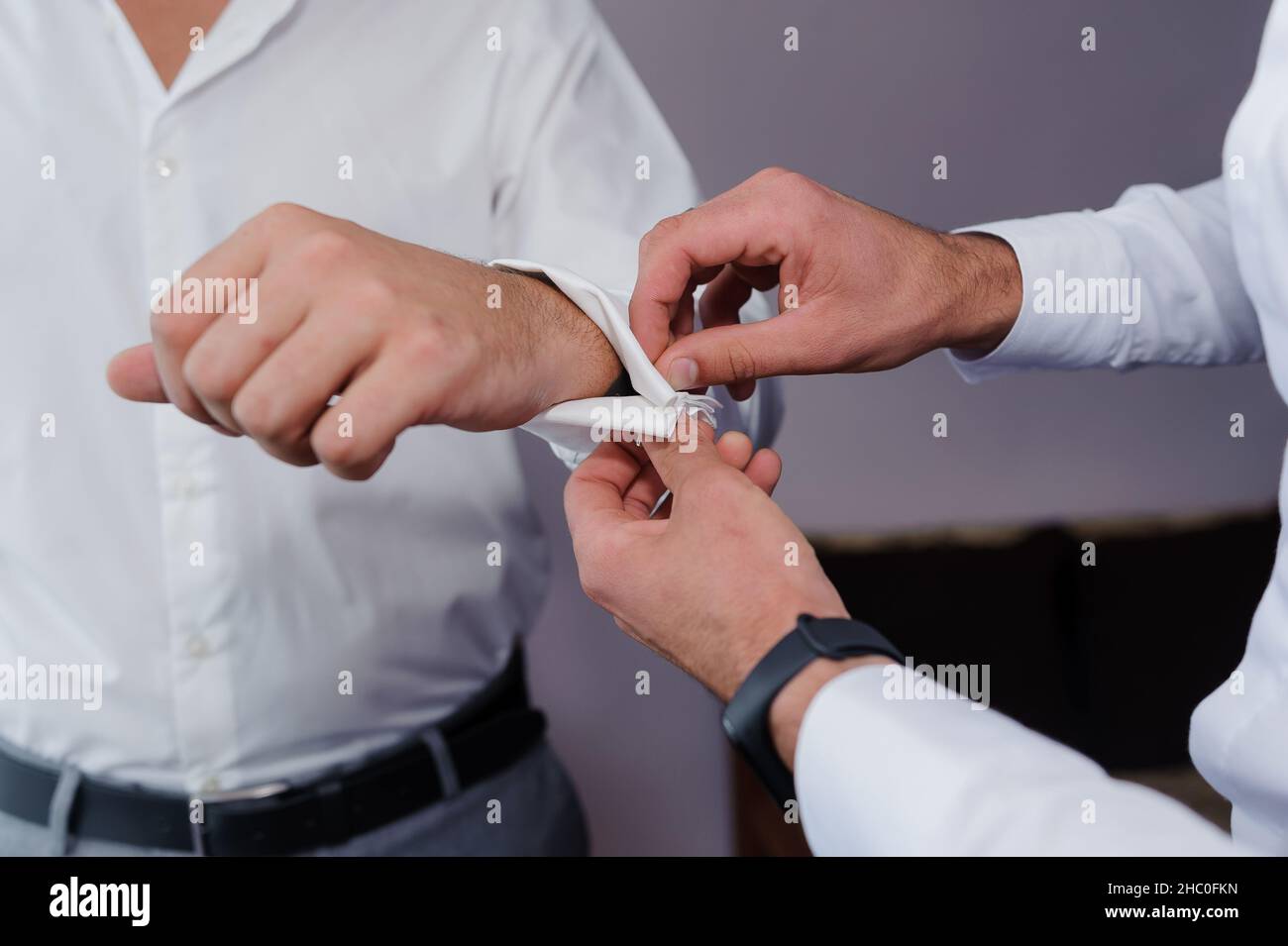 Homme attachant un lien de manchette sur la chemise.Le marié fixe les boutons de manchette sur la chemise Banque D'Images