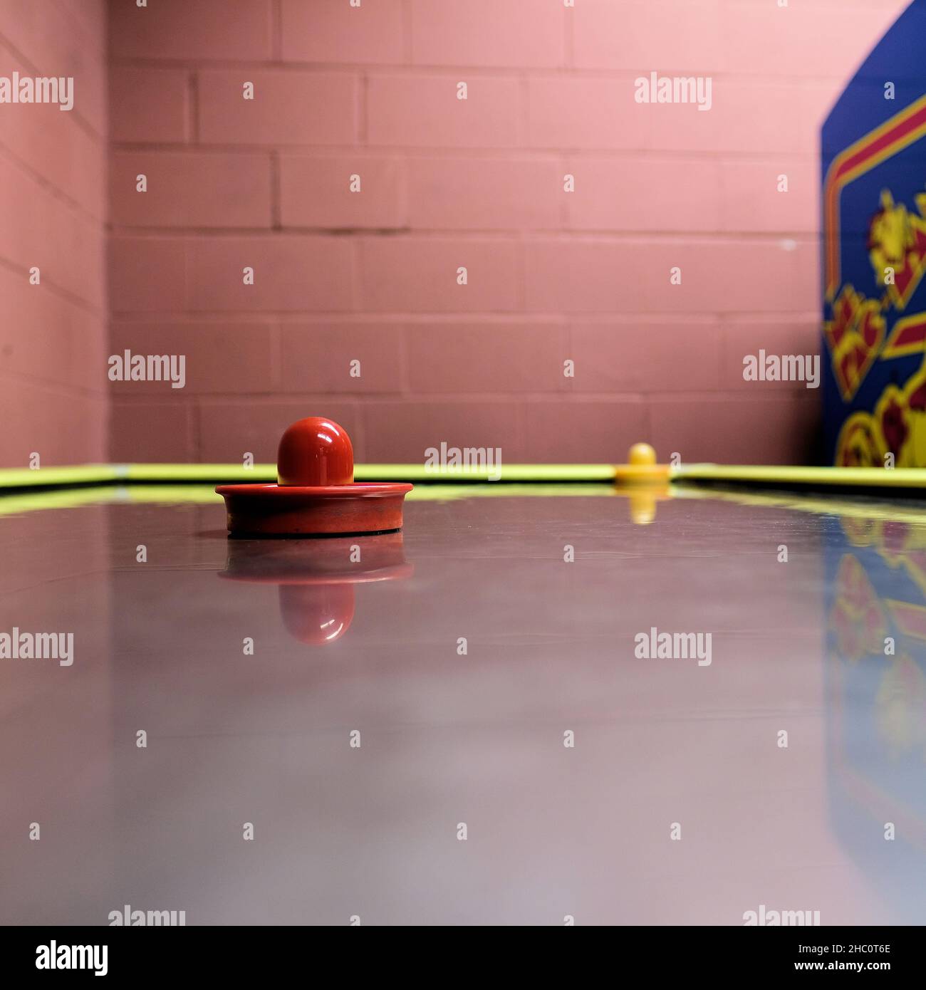 Surface de table de hockey pneumatique avec palettes de gardien de but et une console de jeu Mme Pacman en arrière-plan dans une salle de jeux et d'arcade. Banque D'Images