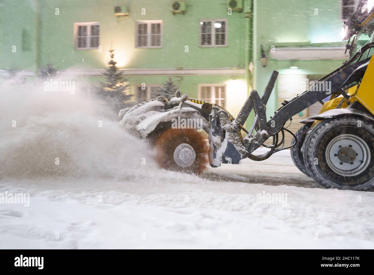 Nettoyer la neige de la route.Le tracteur de chasse-neige en ville souffle de neige de la rue pour la sécurité du transport Banque D'Images