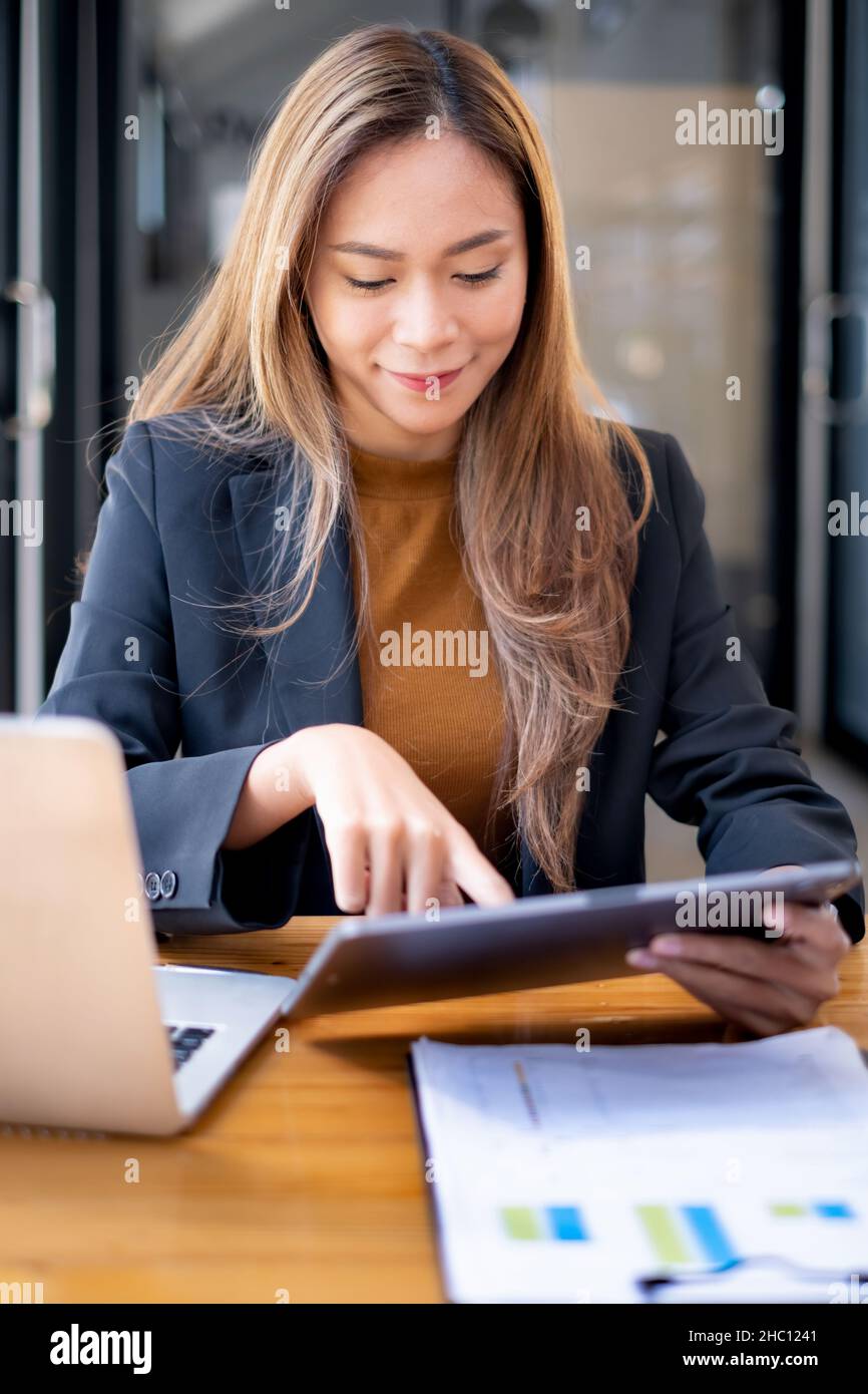 Concept financier et comptable.Femme d'affaires utilisant une application de sécurité sur une tablette pour protéger son argent. Banque D'Images