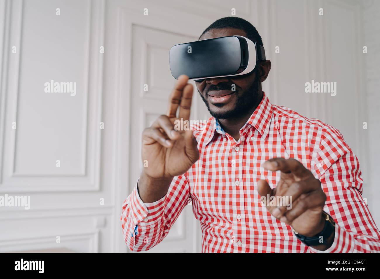 Un jeune homme africain porte des lunettes VR et profite d'une expérience de jeu à la maison Banque D'Images