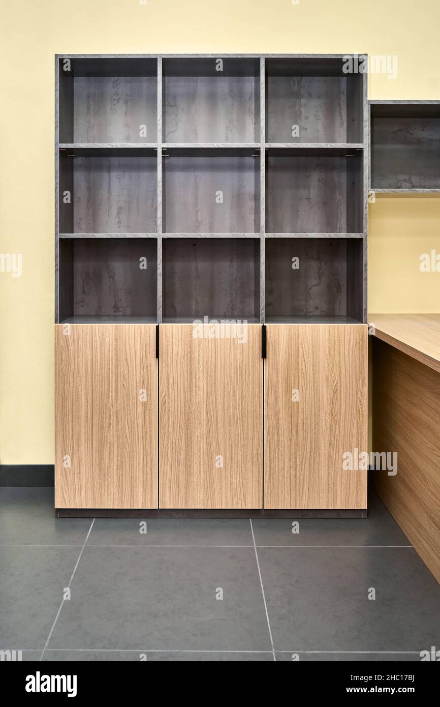 Armoire de rangement de bureau pour documents avec étagères vides en carton laminé avec texture bois et pierre dans un bureau spacieux Banque D'Images