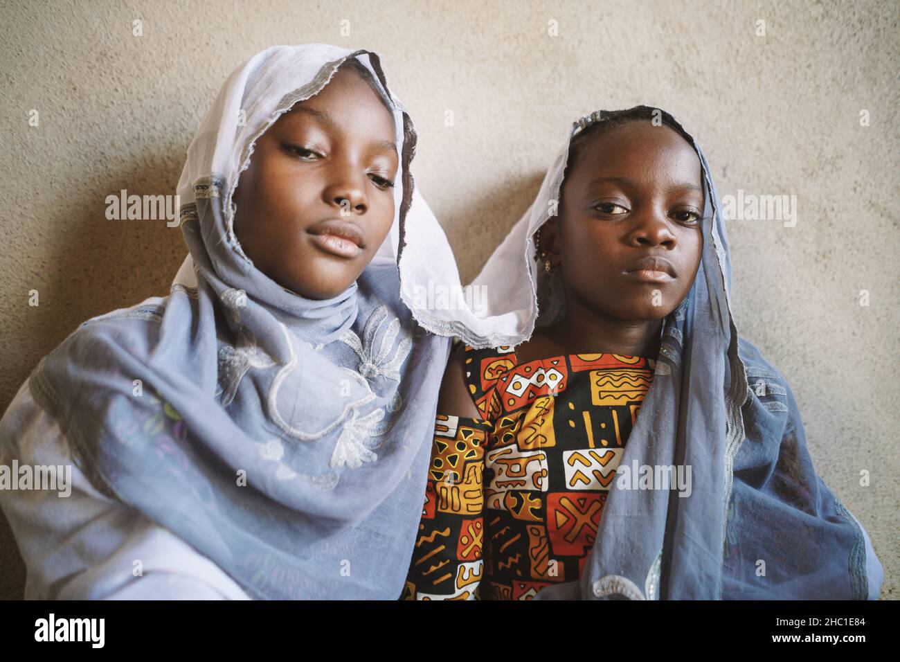 Deux sœurs africaines noires en deuil qui cherchent symboliquement une protection sous le foulard de leur mère; traiter le chagrin chez les enfants concept Banque D'Images