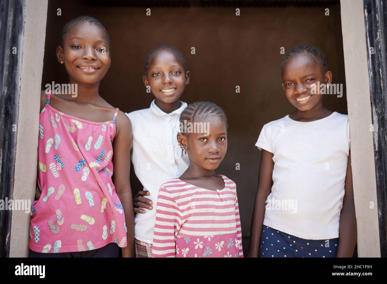 Groupe de quatre jeunes filles noires africaines dans des vêtements décontractés souriant à l'appareil photo et montrant un comportement détendu et confiant Banque D'Images