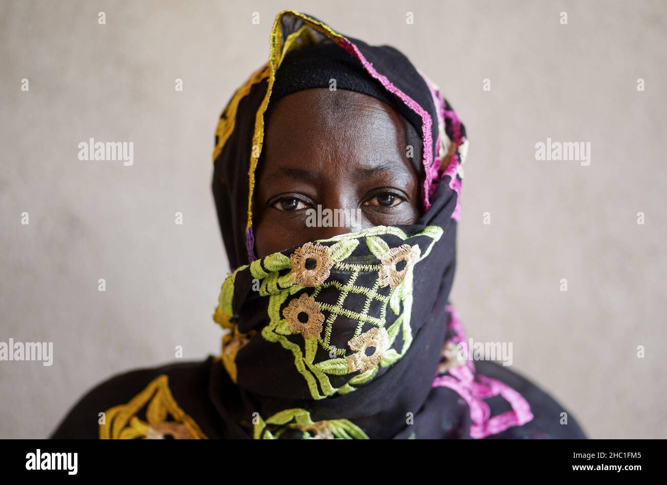 Vieille femme africaine noire, avec la tête de bouche et les épaules couvertes par un voile brodé, regardant blanchir dans l'espace; concept de santé ogntive chez les personnes âgées Banque D'Images