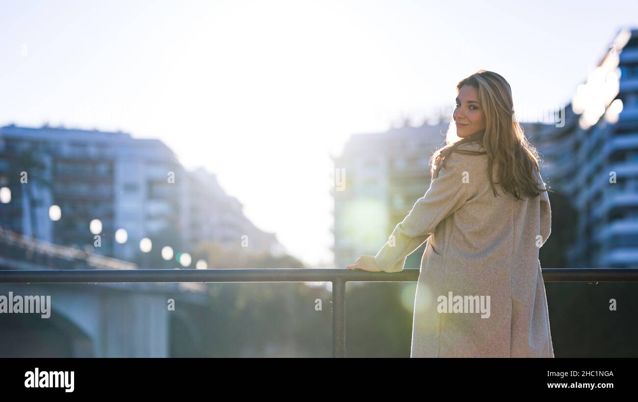 Portrait d'une jeune femme confiante regardant l'appareil photo de derrière Banque D'Images
