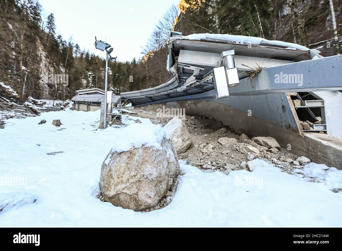 21 décembre 2021, Bavière, Schönau am Königssee: La partie supérieure de la piste endommagée par les inondations (r) à la patinoire artificielle de Königssee et le bâtiment supérieur, non endommagé de départ.Les opérateurs prévoient de raccourcir quelque peu la voie et de la réparer d'ici 2023.Photo: Tobias Hase/dpa Banque D'Images