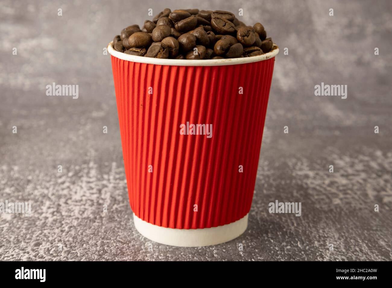 Grains de café dans une tasse en papier rouge Banque D'Images