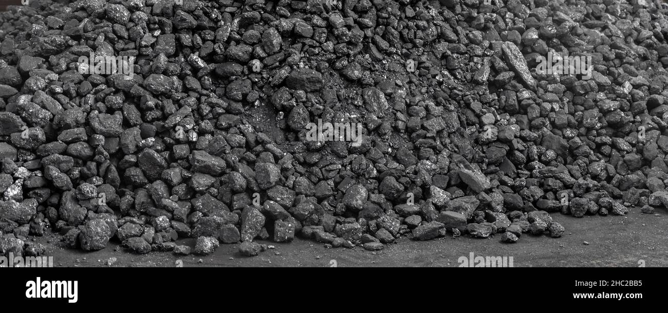 Gros tas de charbon noir foncé sur le plancher en vrac.Charbon de bois à la réserve de stock d'entrepôt. Pile anthracite activée.Production d'électricité et de chaleur Banque D'Images