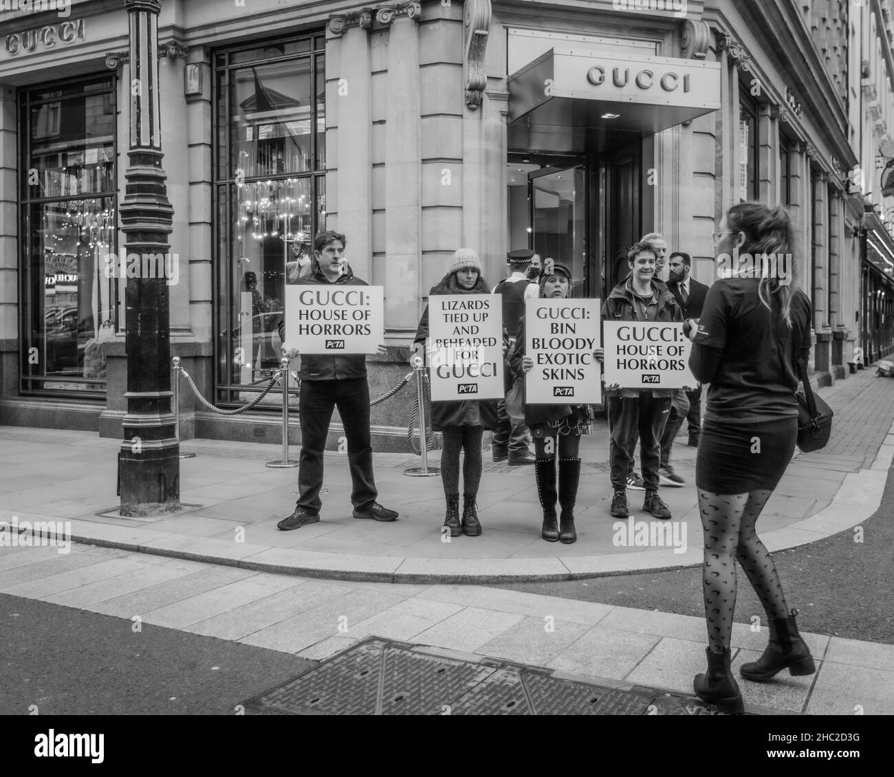 Les activistes tiennent des pancartes exigeant que Gucci cesse d'utiliser des peaux exotiques pour leurs ceintures et sacs à main. Banque D'Images