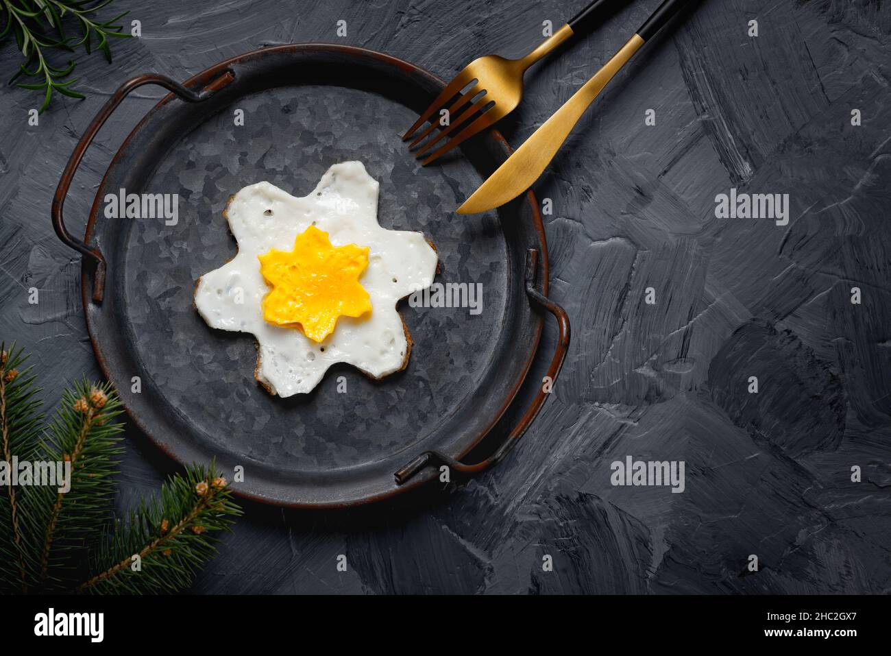 Œuf frit fait maison dans une poêle d'époque sur fond gris.Jaune en forme d'étoile. Banque D'Images