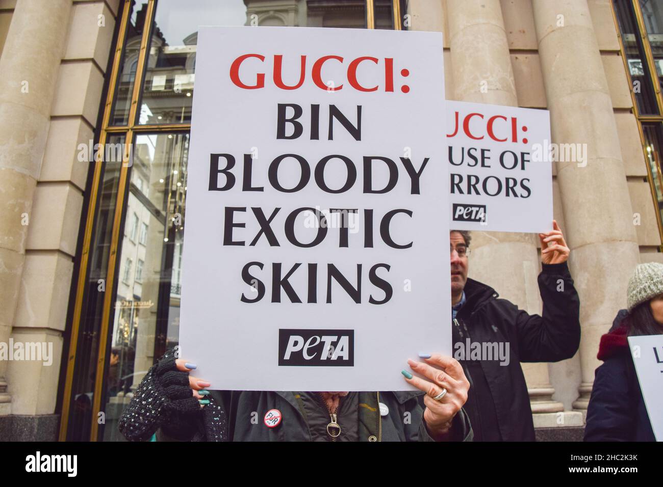 Un activiste tient un écriteau exigeant que Gucci cesse d'utiliser des peaux exotiques, pendant la protestation.PETA (peuple pour le traitement éthique des animaux)Des activistes se sont rassemblés devant le magasin Gucci de Bond Street et ont organisé une « passerelle » avec des sacs à main éclaboussés de faux sang pour protester contre l'utilisation de peaux de lézard dans les produits de Gucci.L'enquête de PETA a montré que les fournisseurs de peau de lézard tombent bien en dessous des normes de bien-être des animaux et causent d'énormes souffrances pour les animaux. Banque D'Images