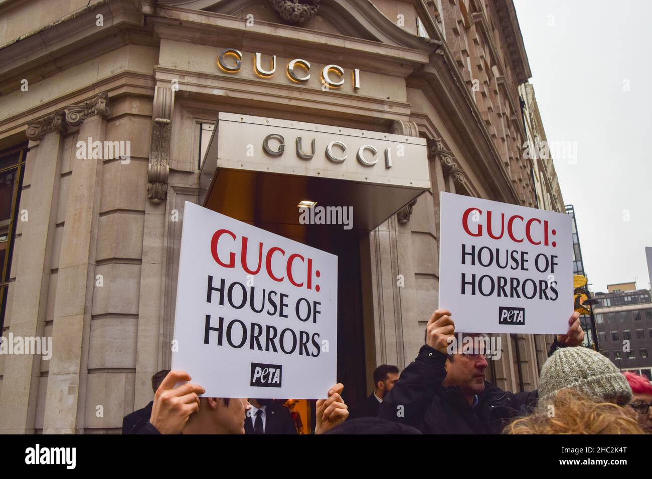 Les activistes tiennent des pancartes de la « Gucci: House of Horrors » pendant la manifestation.les militants du PETA (People for the Ethical Treatment of Animals) se sont rassemblés devant le magasin Gucci de Bond Street et ont organisé une « passerelle » avec des sacs à main éclatés de faux sang pour protester contre l'utilisation de peaux de lézard dans les produits de Gucci.L'enquête de PETA a montré que les fournisseurs de peau de lézard tombent bien en dessous des normes de bien-être des animaux et causent d'énormes souffrances pour les animaux. Banque D'Images