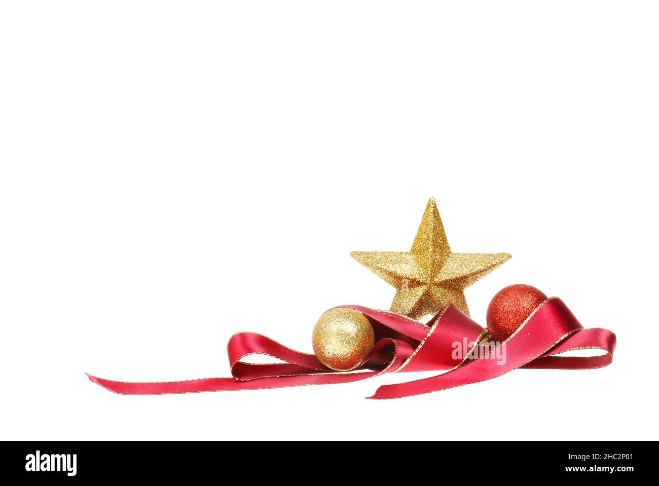 Décoration de Noël, étoile dorée scintillante avec ruban rouge spiralé et boules isolées du blanc Banque D'Images
