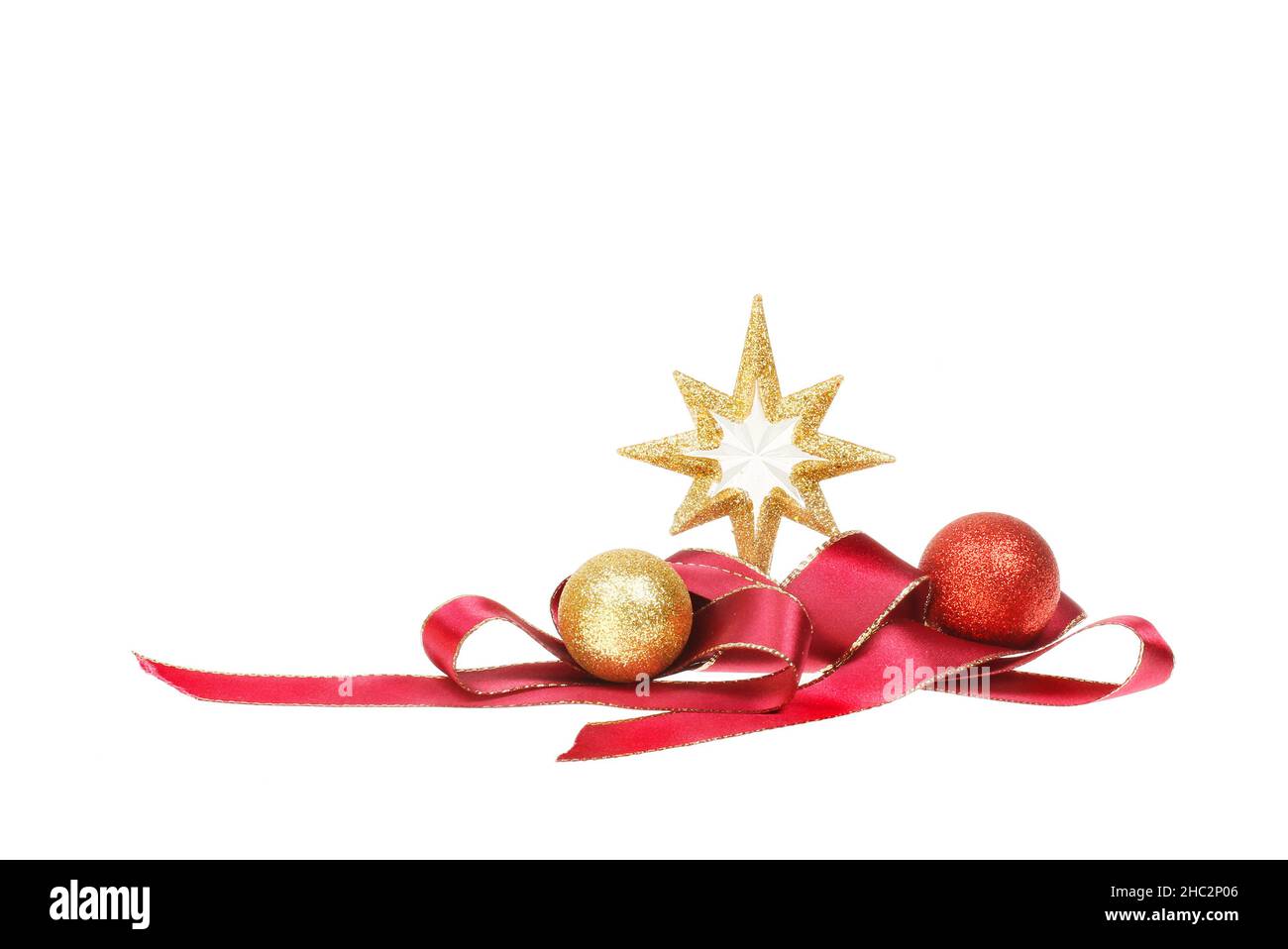 Décoration de Noël, étoile dorée scintillante avec ruban rouge spiralé et boules isolées du blanc Banque D'Images