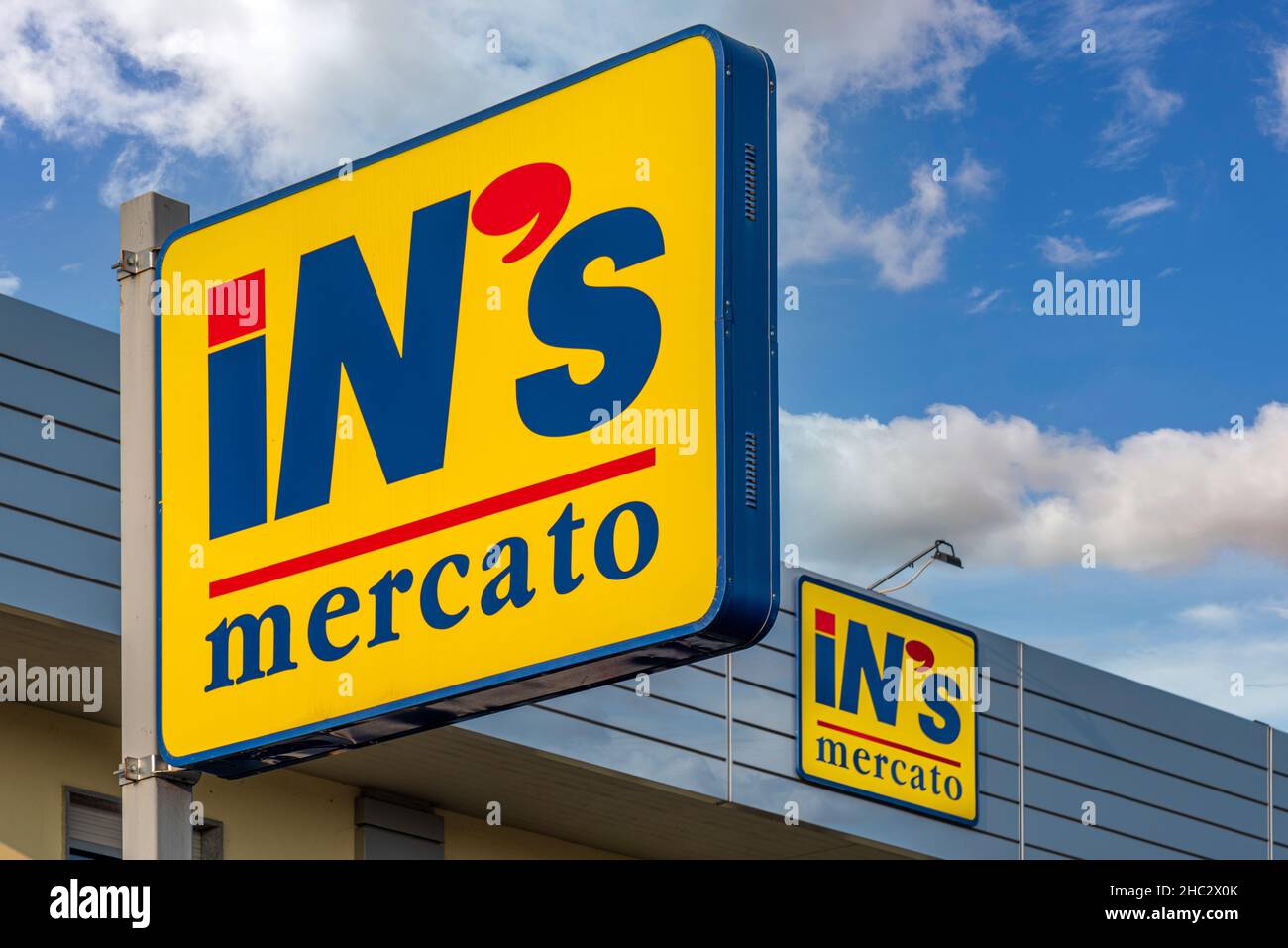 Fossano, Cuneo, Italie - 23 décembre 2021: Signes avec LE logo MERCATO D'IN sur ciel bleu ciel nuageux, INN'S Mercato est une chaîne de supermarchés à prix réduit italienne de Banque D'Images