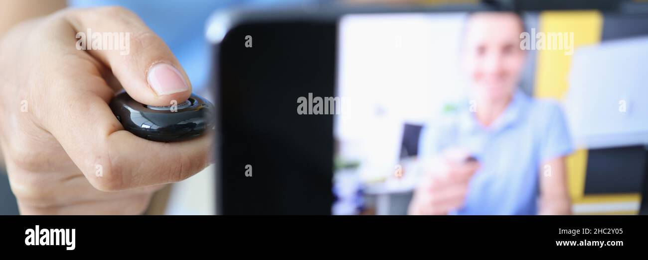 Femme appuie sur le bouton du panneau de commande et enregistre des vidéos sur smartphone sur trépied Banque D'Images