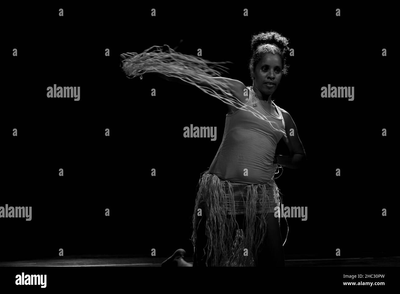 Danseuse contemporaine dansant au théâtre avec fond noir et accessoire paille.Salvador Bahia Brésil. Banque D'Images