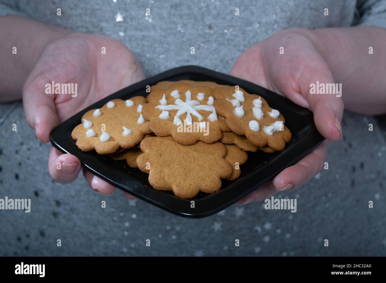 Helsinki / Finlande - 12 DÉCEMBRE 2021 : une femelle caucasienne tenant une plaque de biscuits au pain d'épice. Banque D'Images