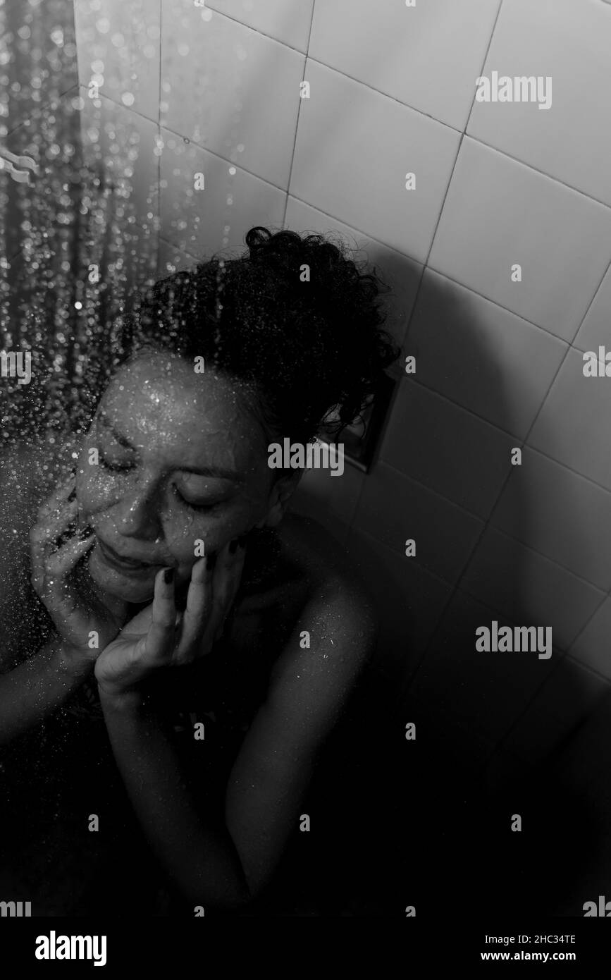 Portrait d'une femme dans la salle de bains se lavant elle-même.Salvador, Bahia, Brésil. Banque D'Images