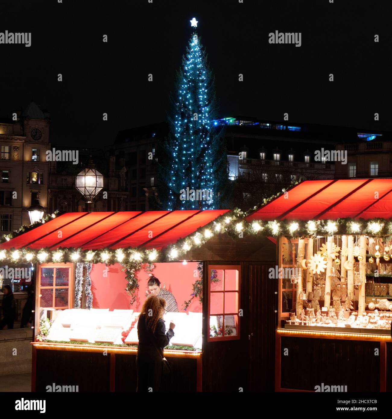 Londres, Grand Londres, Angleterre, décembre 15 2021 : personnes fréquentant un marché de Noël à Trafalgar Square avec l'arbre de Noël offert de Norvège Banque D'Images