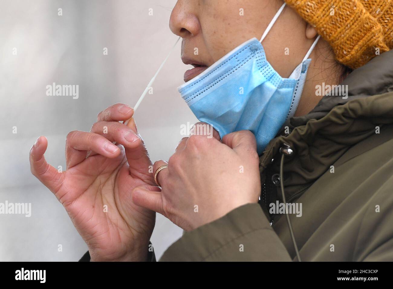 New York, États-Unis.23rd décembre 2021.Une femme se met à l'intérieur de son nez lorsqu'elle passe un test PCR sur le site de test Federal COVID-19, situé à côté du terrain de jeu Helen Marshall, dans le quartier Queens de New York, NY, le 23 décembre 2021.Alimenté par la variante Omicron, New York établit un autre record quotidien des cas COVID-19, alors que la CDC établit plusieurs « accès communautaire croissant aux équipes de test, appelé ICATT, sites de test mobiles dans les districts ; NY a maintenant un taux de positivité de près de 12%.(Photo par Anthony Behar/Sipa USA) crédit: SIPA USA/Alay Live News Banque D'Images